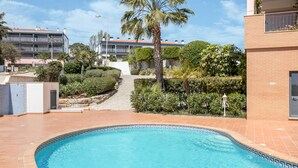 A swimming pool with a geometric tile border, surrounded by a landscaped garden with a palm tree and various shrubs. - Apartment "Meia Praia Beach" with Sea View, Pool, Wi-Fi, Balcony & Garden (Lagos)