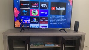A television on a wooden entertainment center with a shelf below displaying board games. - Hidden gem close to everything!!! (Sarasota)