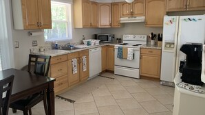A kitchen with wooden cabinets, a white stove, a microwave, and a refrigerator. - Hidden gem close to everything!!! (Sarasota)