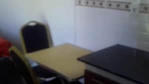A small, dimly lit room with a single table and two chairs.