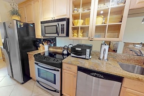 A kitchen with stainless steel appliances, a microwave, a toaster, and a dish rack. - Bayside Corner Unit, Dog OK, Walk to Turtle Beach (Sarasota)