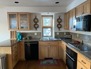 Enjoy cooking in this well-lit kitchen with a dishwasher, oven, and microwave.