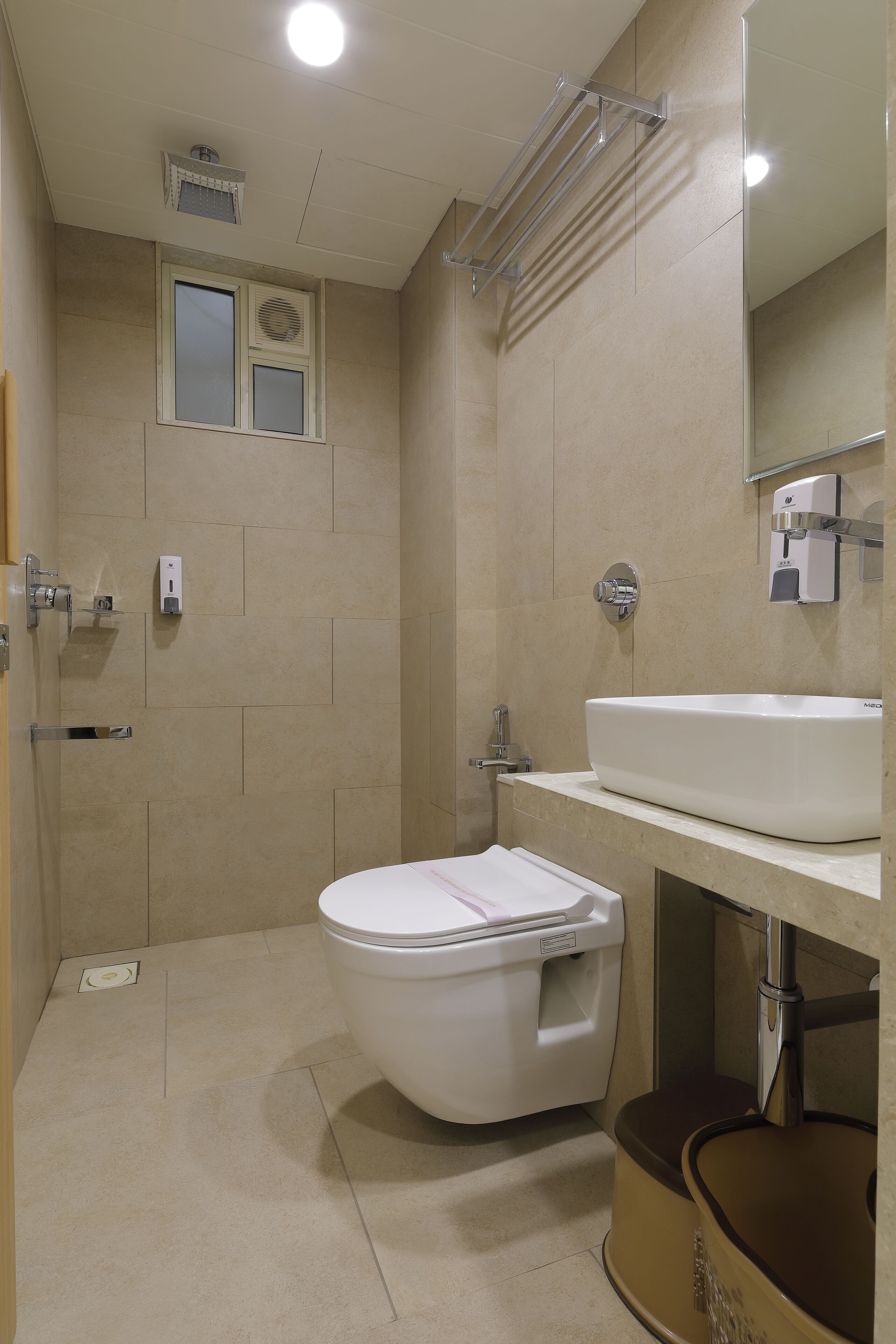 Un baño moderno con inodoro, lavamanos y zona de ducha.