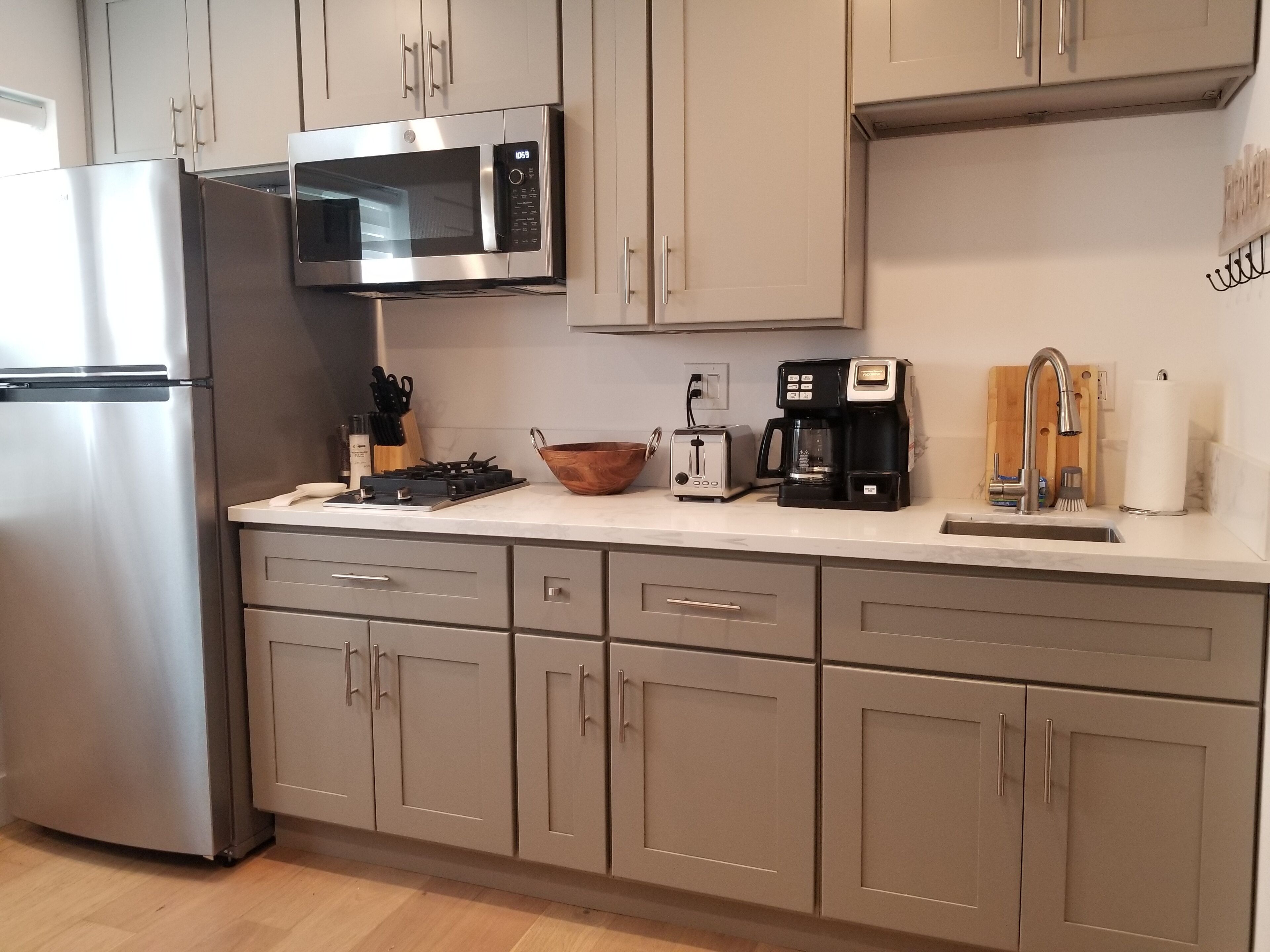 A modern kitchen with stainless steel appliances, a microwave, a toaster, and a coffee maker.