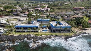 Ein Küstenhotel mit mehreren Gebäuden, einem Schwimmbad und einer felsigen Küstenlinie.