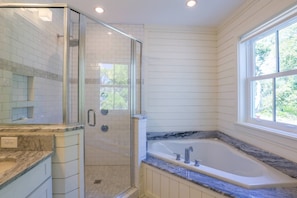 A bathroom with a glass-enclosed shower, a large bathtub, and a window providing natural light. - Private Pool & Hot Tub; Spacious Roof Deck w/ Views of Ocean;  2 Master Suites; 1 Block to Beach! (Isle of Palms)