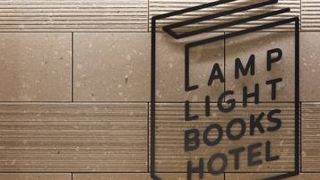 Une enseigne pour l’hôtel Lamp Light Books, avec un motif géométrique et le nom de l’hôtel clairement affiché.
