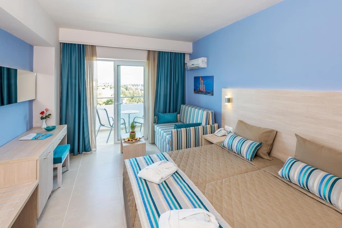 A hotel room with a bed, a sofa, a desk, and a balcony.