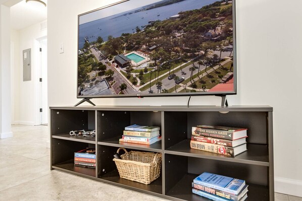 Un televisor que muestra una vista aérea de una zona costera con piscina, rodeada de vegetación y edificios.