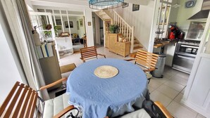 Un comedor con una mesa redonda, sillas y una lámpara colgante.
