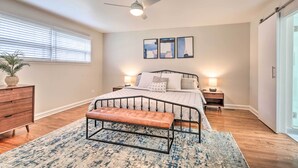 A bedroom with a bed, bedside tables, a bench, a ceiling fan, and a window with blinds. - Home w/ Office + Yard: 25 Mi to Downtown Chicago! (Glen Ellyn)