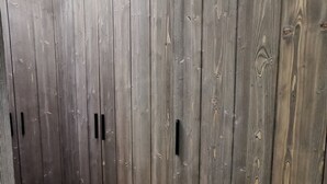 A room with vertical wooden paneling and black handles on the doors. - Flat for 4, central Les Gets, WiFi, parking (Les Gets)