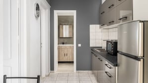 A modern kitchen with a built-in microwave, stainless steel refrigerator, and wooden cabinets. - Ionian Sea View Apartments at Barbati by Konnect (Corfu)