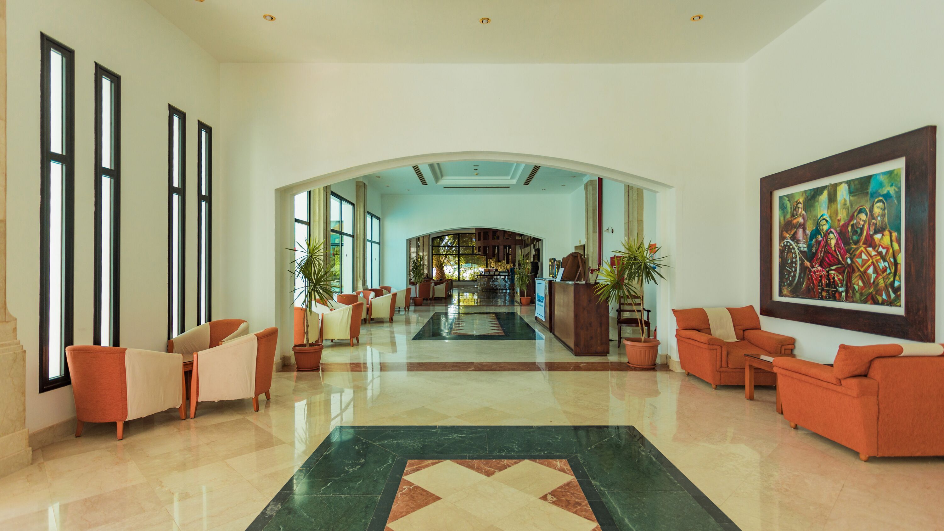 A spacious lobby with a central archway, seating areas, and a reception desk.