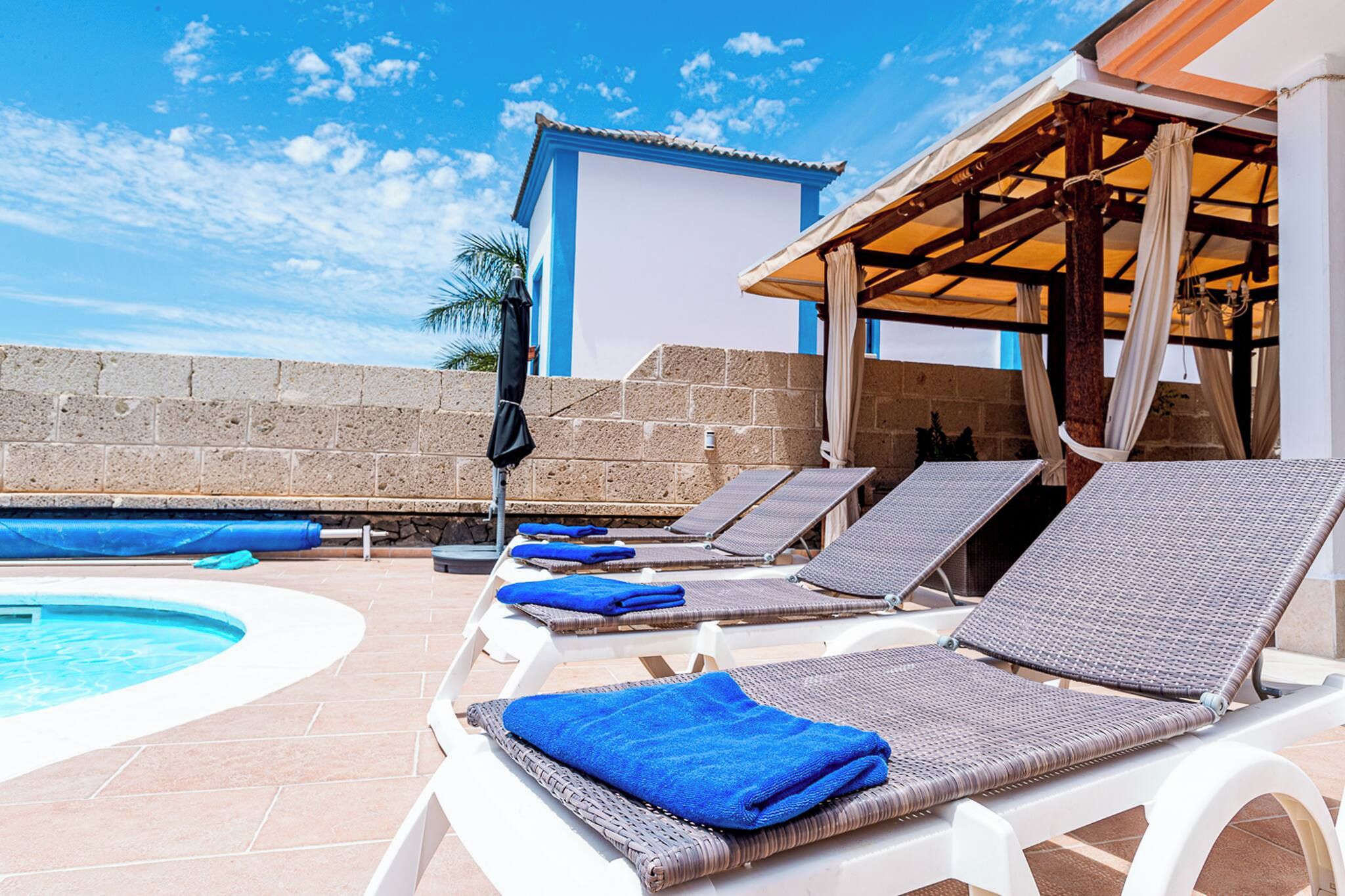 A poolside area with lounge chairs and a pool.