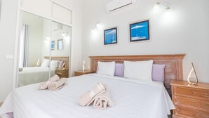 A hotel room with a large bed, a bedside table, a mirror, and two framed pictures on the wall. - Villa with pool in Madroñal Fañabe, Costa Adeje (Costa Adeje)