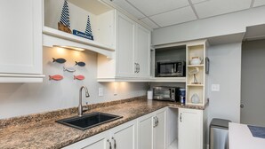 A kitchen with white cabinets, a granite countertop, a sink, a microwave, and a toaster. - Walk to Town, Riverfront Retreat & Beach Pass (Kennebunk)