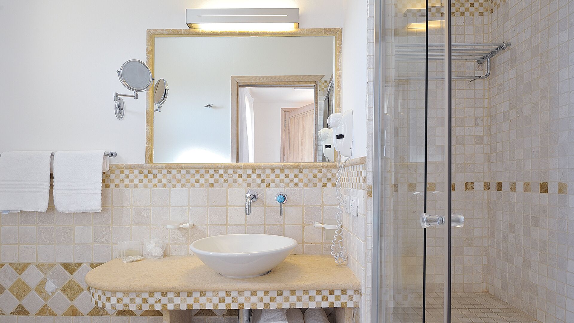 A bathroom with a white sink, a large mirror, and a shower area.