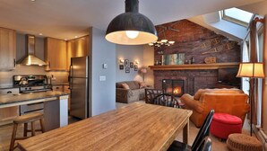 Una cocina moderna con comedor, chimenea y un altillo con tragaluz.