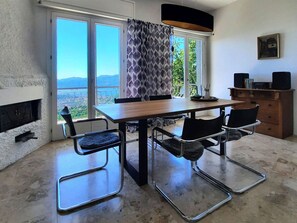 A modern kitchen with a built-in stove, a dining table with four chairs, and a view of the outdoors.