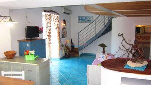 A spacious living area with a staircase, a dining table, and a kitchen area.