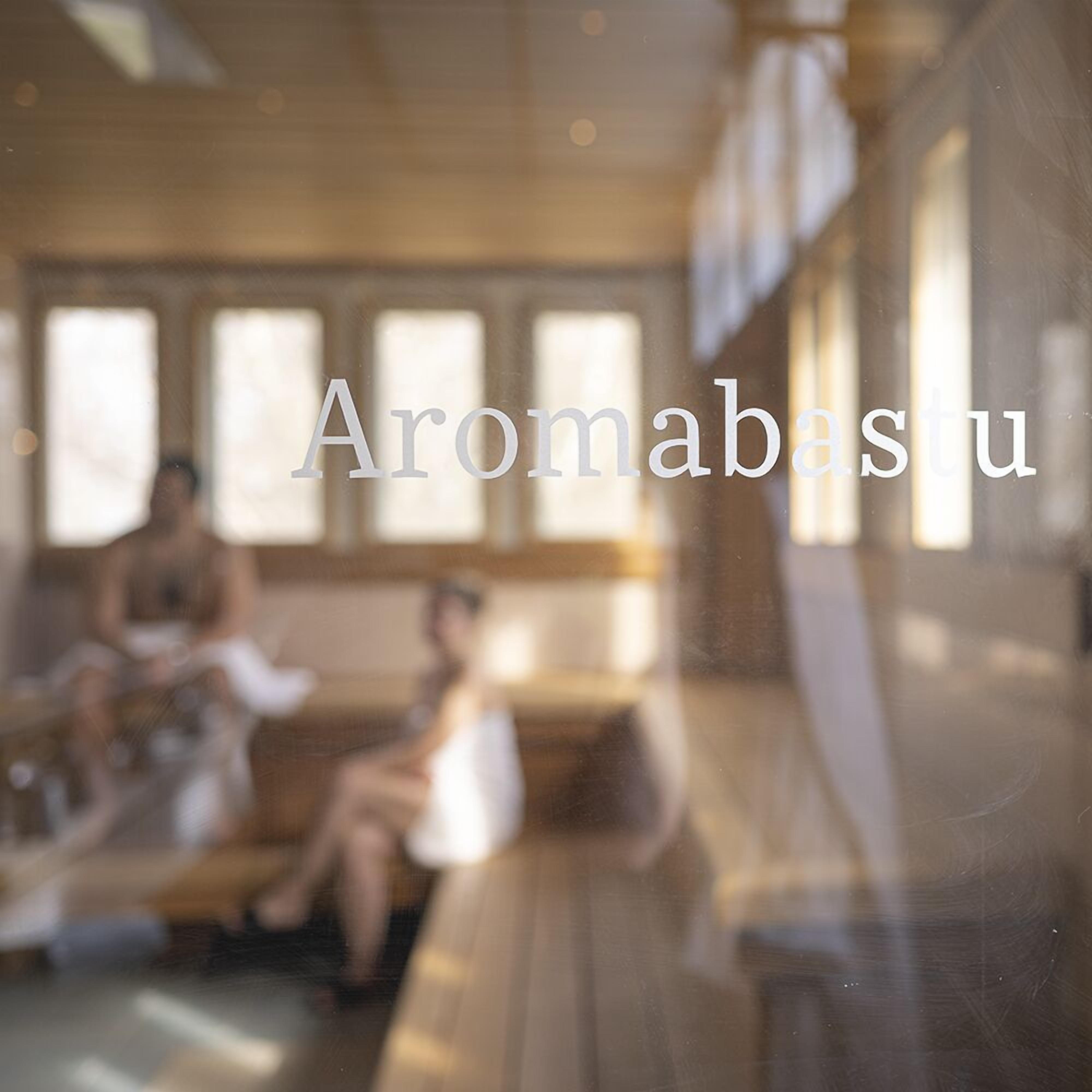 A blurred interior of a spa with the name 'Aromabastu' visible.