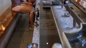Un'area benessere con una lunga panca, una vasca idromassaggio e un pavimento piastrellato.