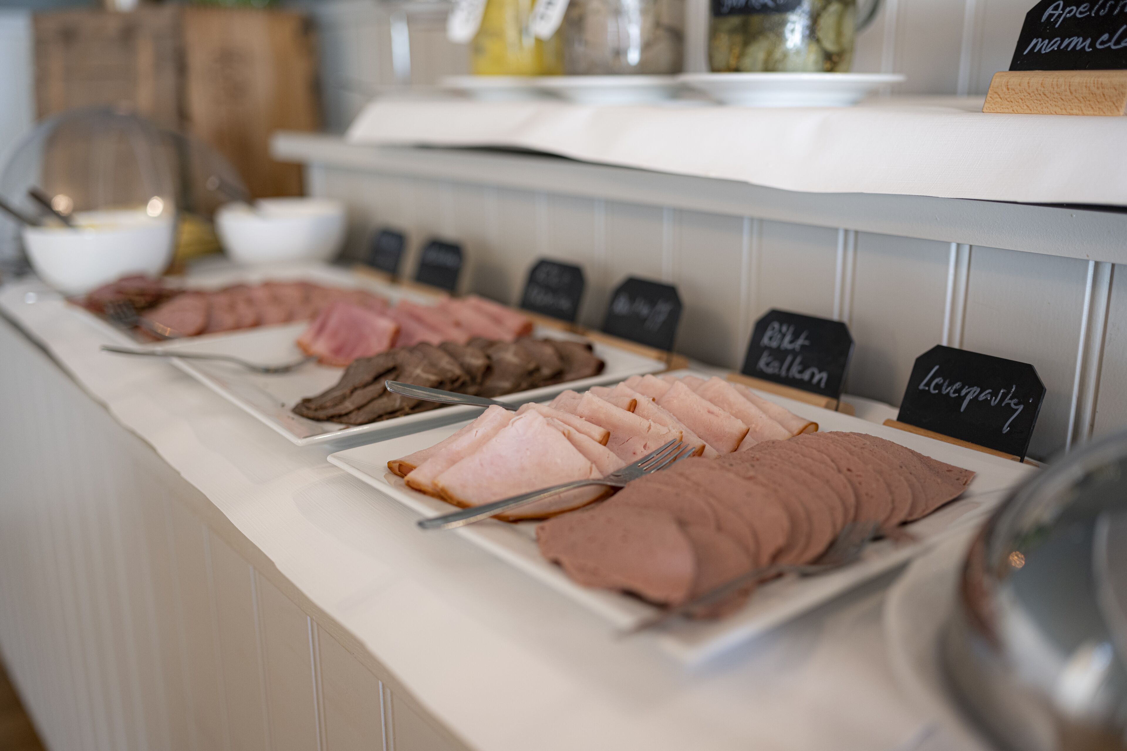A buffet with various types of meat and a sign indicating 'Blue cheese'.
