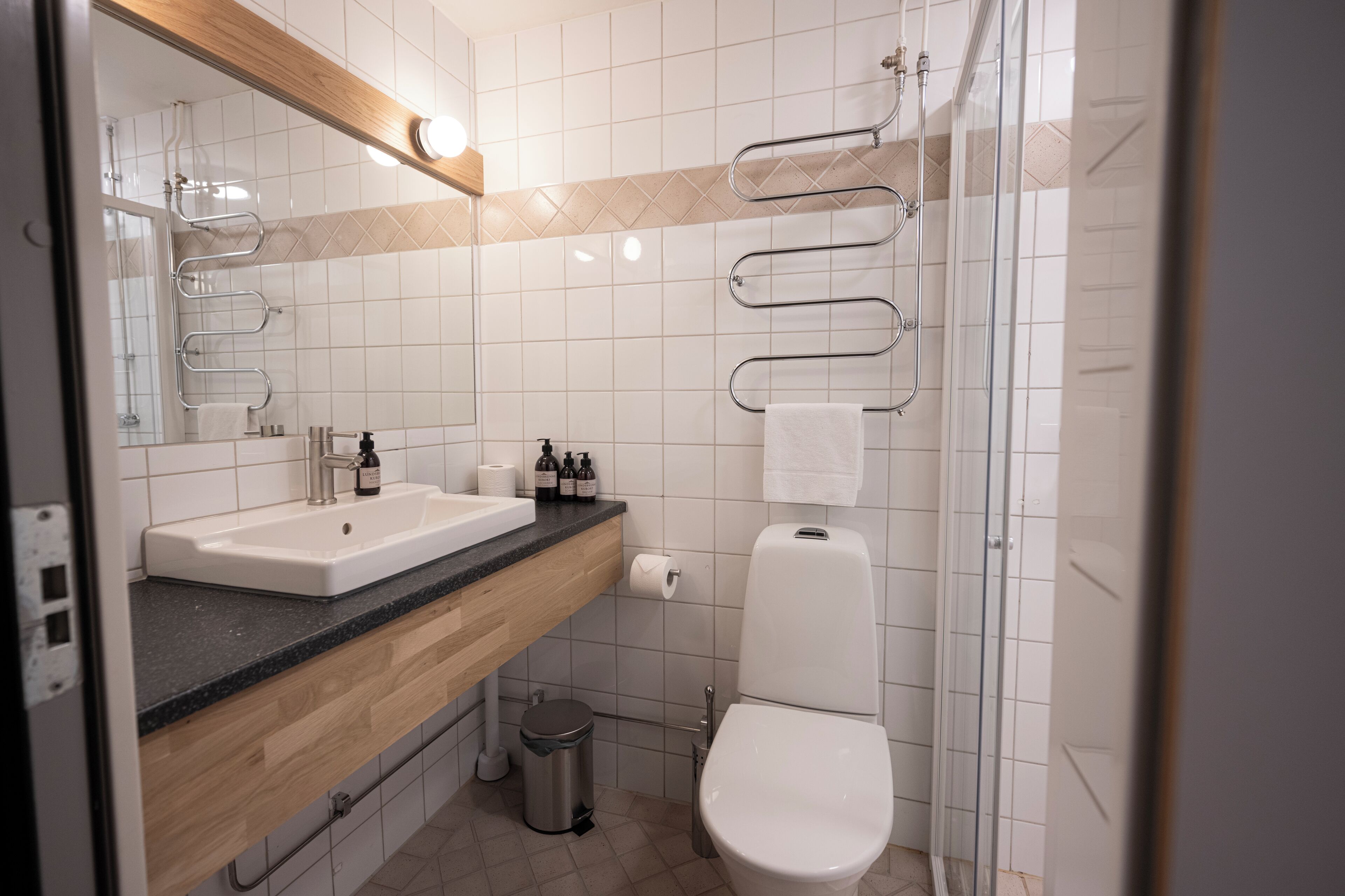 A modern bathroom with a sink, toilet, and shower.