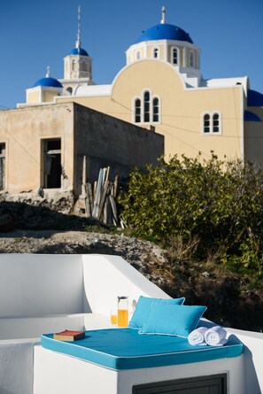 A sunlit outdoor seating area with a view of a building with blue domes.