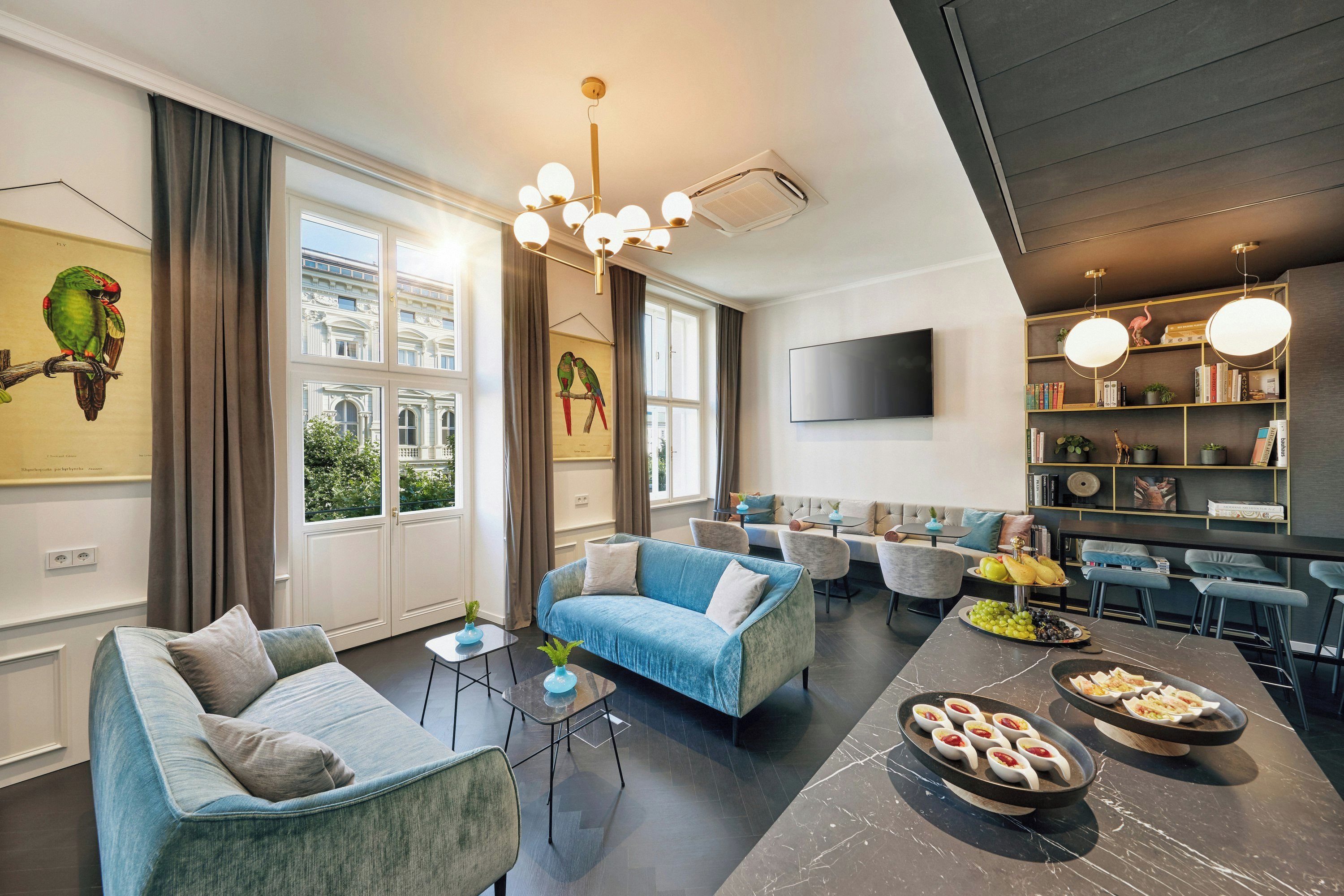 Un salon moderne comprenant un canapé, des fauteuils, une table basse et un coin repas avec un buffet.