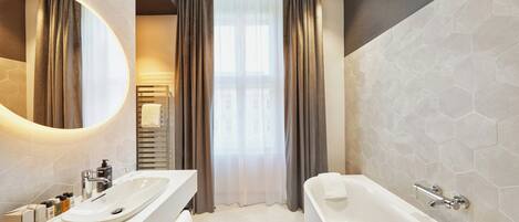 Un baño moderno con una bañera grande, un lavamanos doble y un espejo amplio.