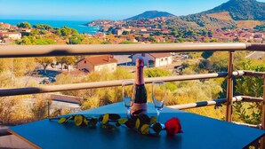 A balcony with a table, a bottle, and a glass. - Magnificent location with breathtaking views of Collioure and the sea (Collioure)