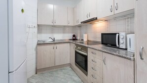 A modern kitchen with light wood cabinets, a stainless steel sink, a built-in oven, and a microwave. - VIEWS OF THE BAY (l'Alfàs del Pi)
