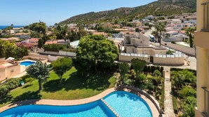 A residential area with a swimming pool, green lawns, and houses with red-tiled roofs. - VIEWS OF THE BAY (l'Alfàs del Pi)