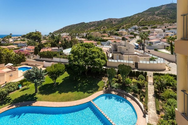 A residential area with a swimming pool, green lawns, and houses with red-tiled roofs. - VIEWS OF THE BAY (l'Alfàs del Pi)