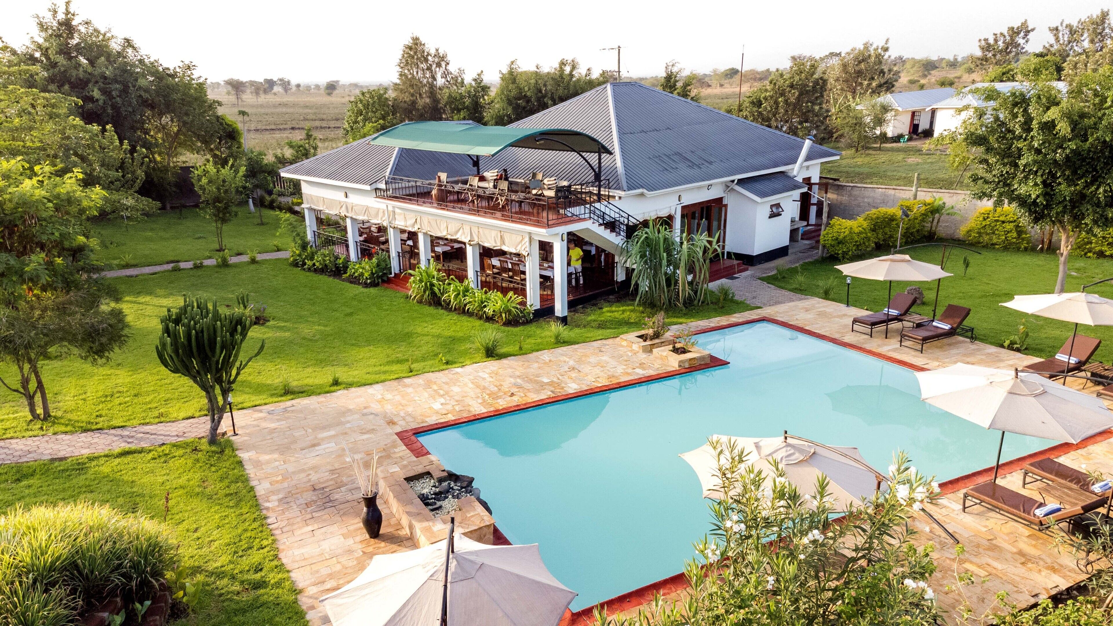 A house with a swimming pool, outdoor seating, and a garden.