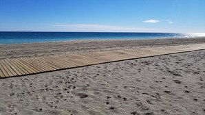 A wooden boardwalk leading to a beach with clear blue water and a clear sky. - Attic apartment in Vera Beach with beautiful sea and mountain views (Vera Playa)