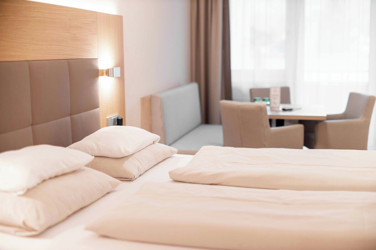 Una habitación de hotel con una cama, un escritorio y una silla.