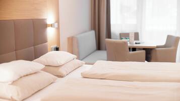 Una habitación de hotel con una cama, un escritorio y una silla.