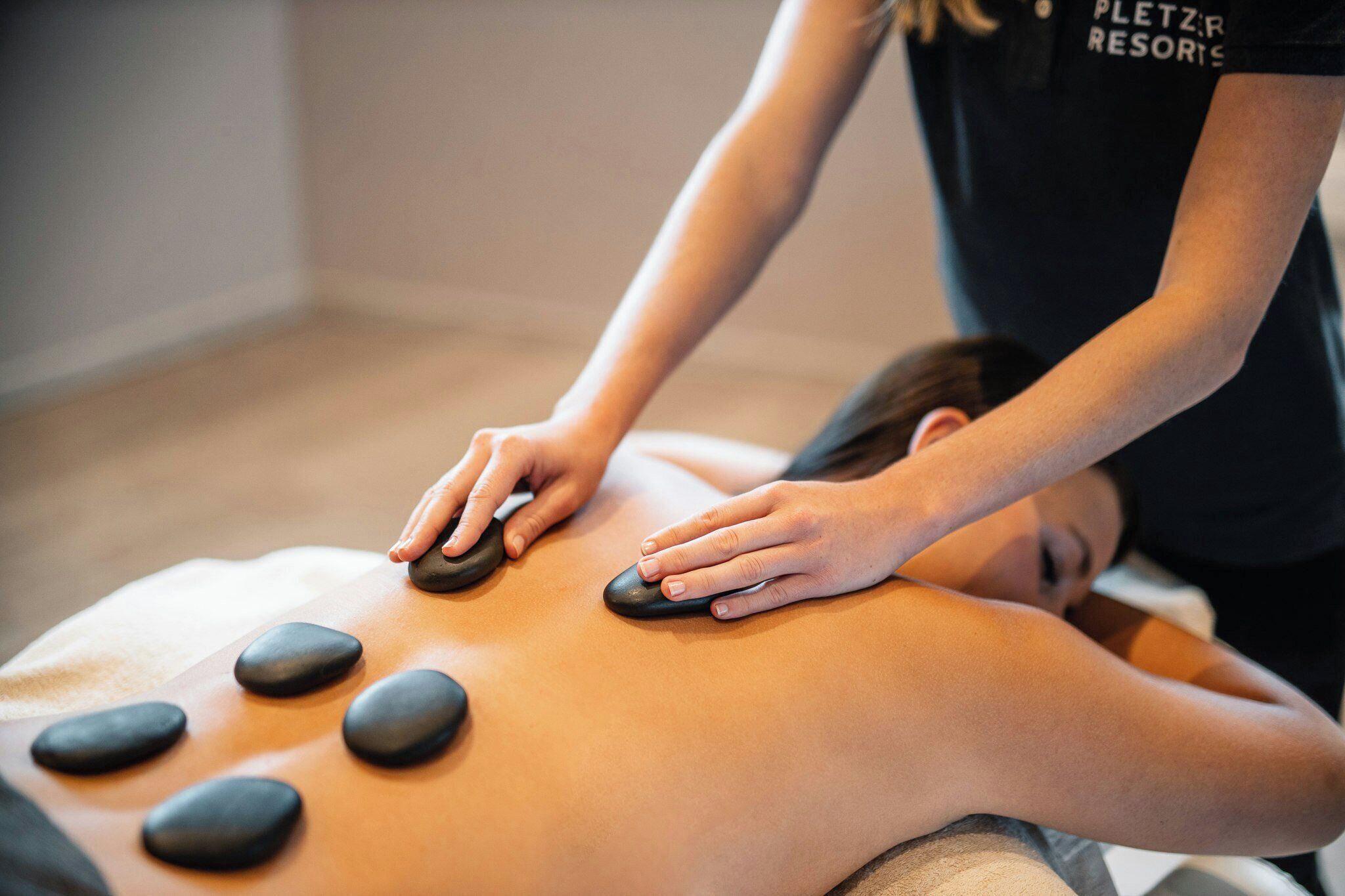 A person receiving a back massage with multiple pressure points.