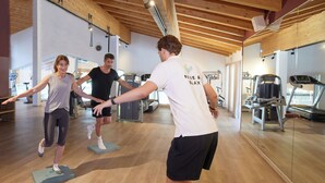 Un gimnasio con piso de madera y equipo de ejercicio.