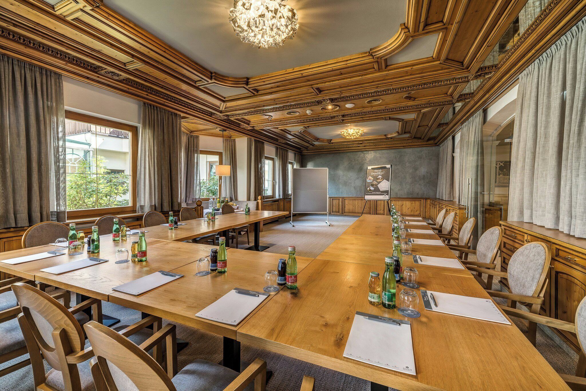A conference room with a long table, multiple chairs, and a whiteboard.