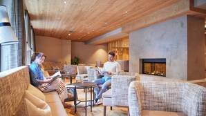 Un salón moderno con sofás, chimenea e iluminación empotrada en el techo.