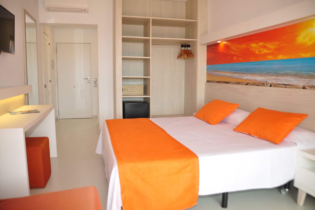 Ein Schlafzimmer mit Bett, Schreibtisch und Kleiderschrank.