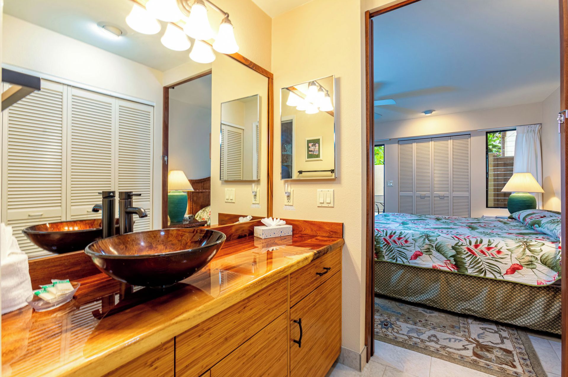 A bathroom with a wooden vanity, two large mirrors, and a vessel sink.