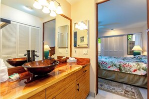 A bathroom with a wooden vanity, two large mirrors, and a vessel sink.