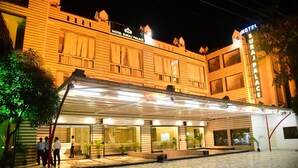 A hotel with a covered entrance, large windows, and a sign reading "Hotel Suraj Palace". - Hotel Suraj Palace (Bhopal)