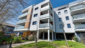 A modern multi-story building with balconies and large windows.
