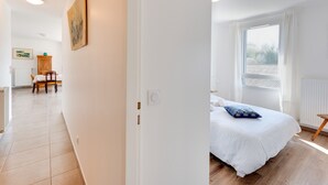 A hotel room with a bed, a window, and a view of the outside.
